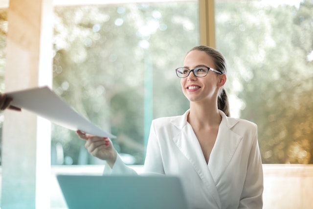 landlord-smiling-sitting-at-desk-being-handed-paperwork