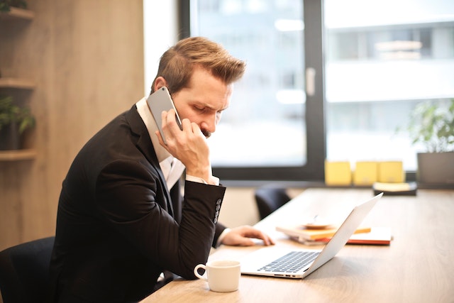 paradise-property-manager-sitting-at-desk-on-phone-with-tenant