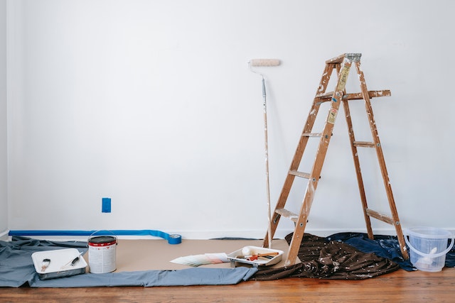 white-wall-with-painting-supplies-and-ladder-in-room